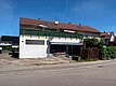 Ansicht von Süden mit Parkplätzen vor dem Haus