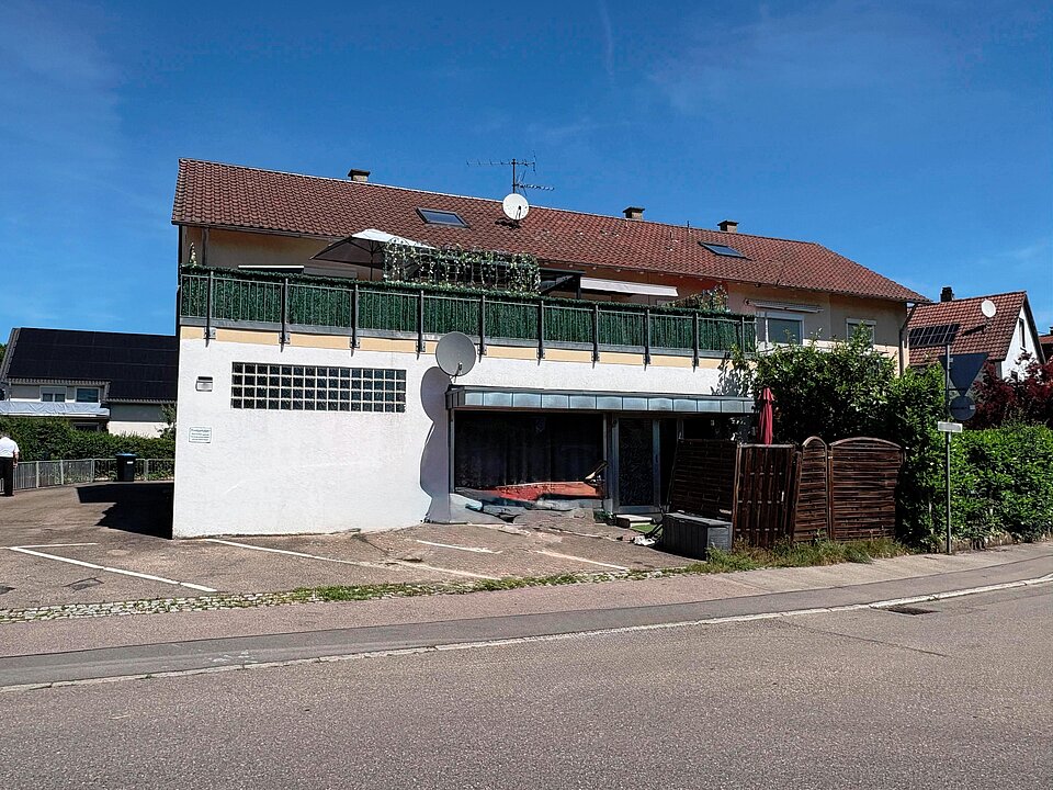 Ansicht von Süden mit Parkplätzen vor dem Haus