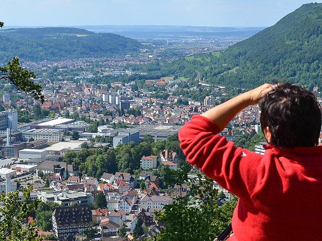 Panoramablick auf die Stadt Geislingen an der Steige von oben, mit einer Person im roten Pullover, die mit dem Rücken zum Betrachter steht und in die Ferne blickt.
